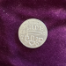 a photo of a silver coin on a purple velvet background