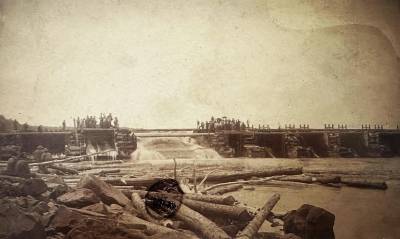 a sepia-toned historical photo of a embankment dam